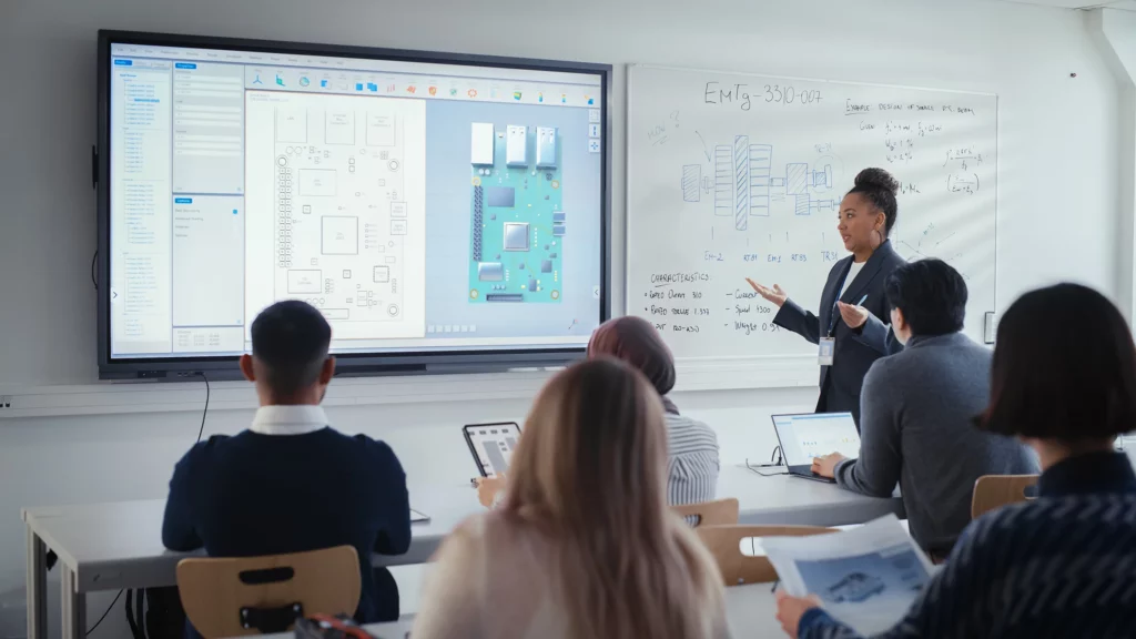 16x9-female-instructor-students-classroom-digital-screen-ADO-544382639.2400